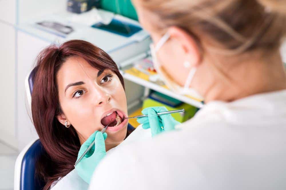 Woman getting an oral exam by a dentist